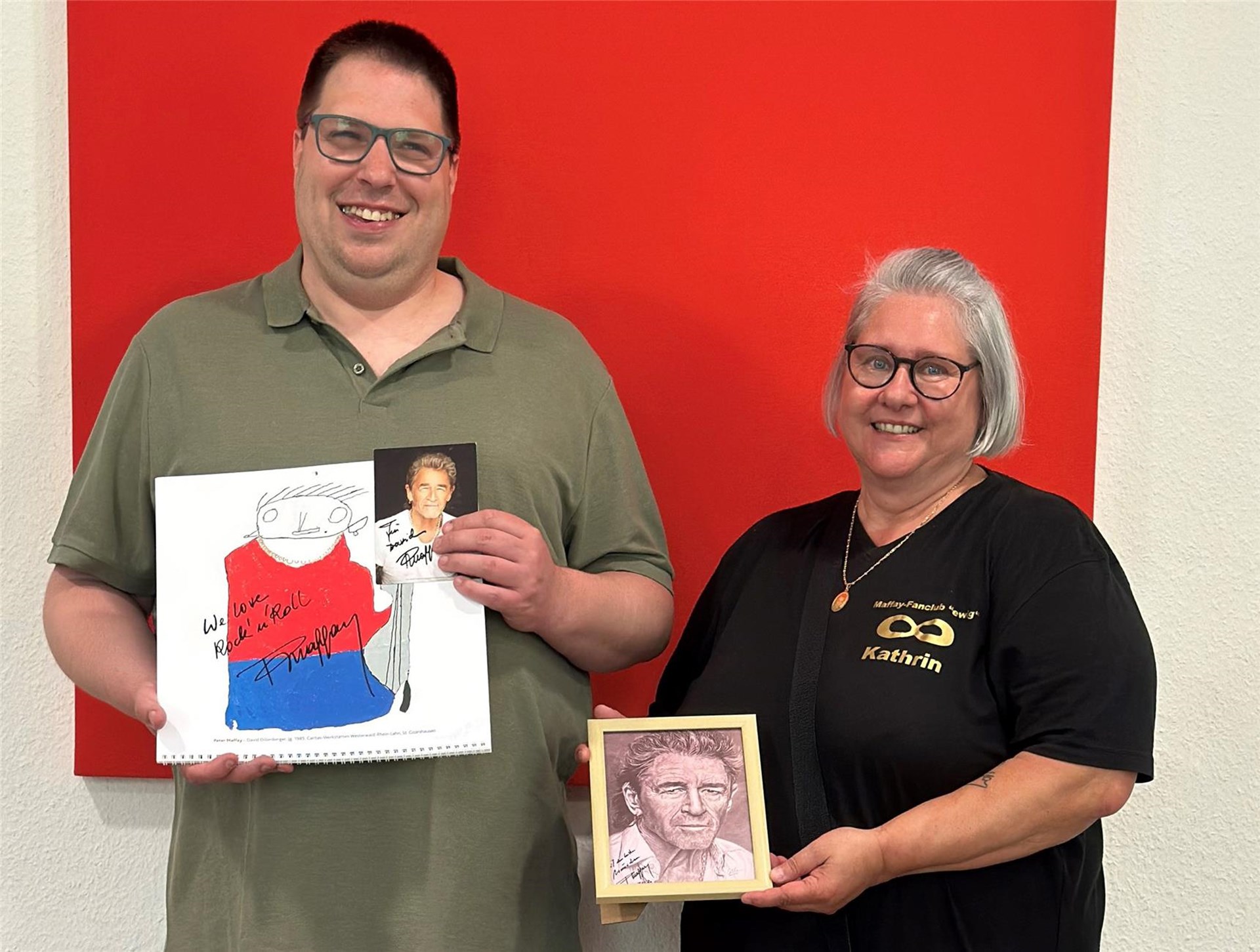 David Dillenberger, Beschäftigter der Caritas-Werkstätten Westerwald-Rhein-Lahn am Standort St. Goarshausen, freut sich gemeinsam mit Kathrin Pölitz vom Peter-Maffay-Fanclub „Ewig“ über sein von Peter Maffay persönlich signiertes Kalenderbild. 