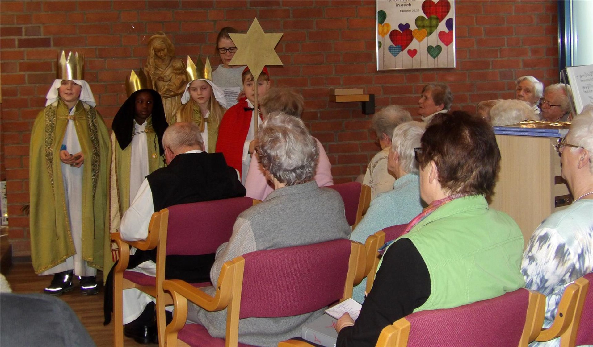 Blick in die Kapelle, wo sich zahlreiche Bewohner:innen zu einenem Gottesdienst mit den Sternsinger:innen eingefunden haben.