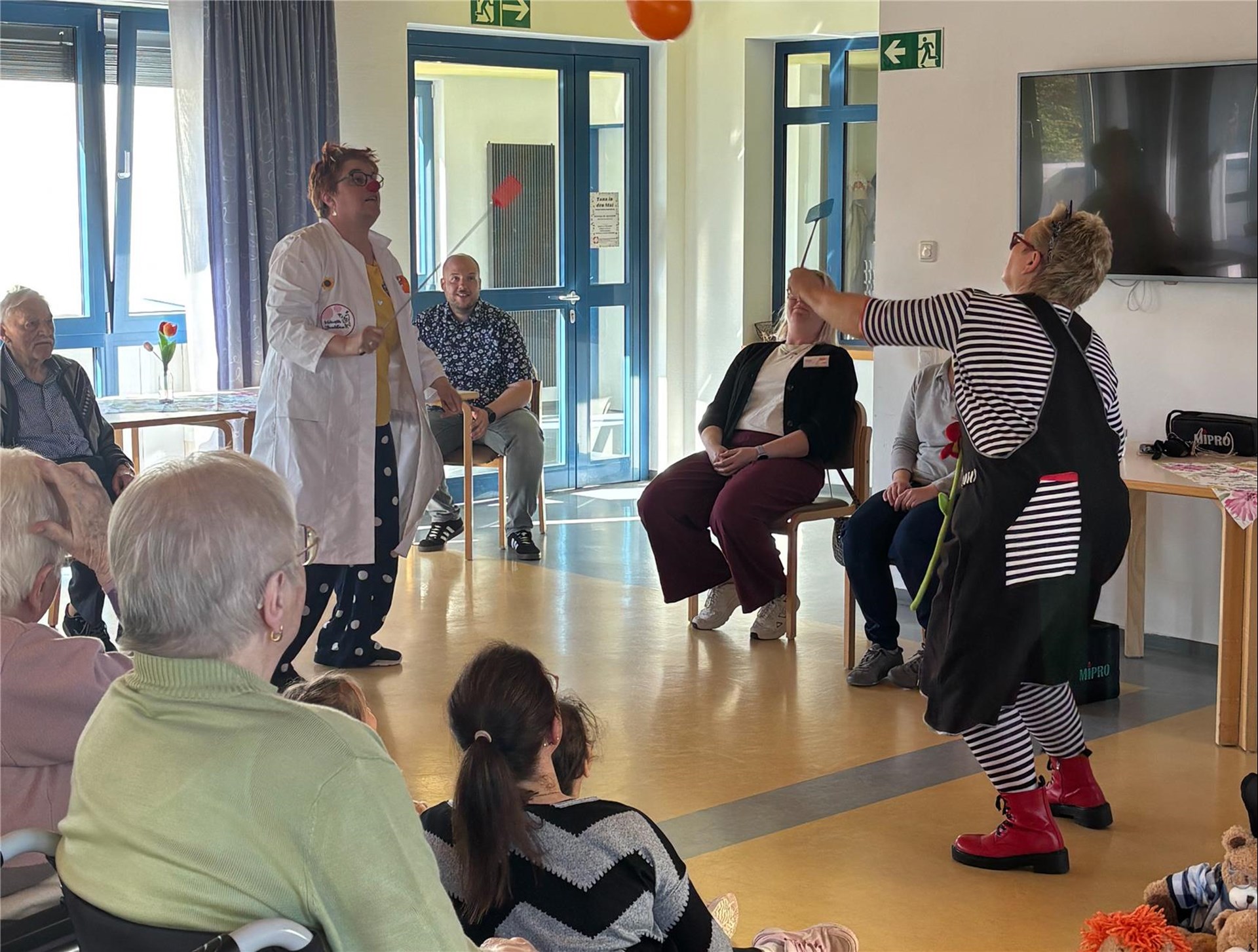 Die Clowndoktoren Jippie Mumpitz und Suseline Glück treten vor Kindern und Seniorinnen und Senioren im Caritas-Altenzentrum Haus Helena auf.