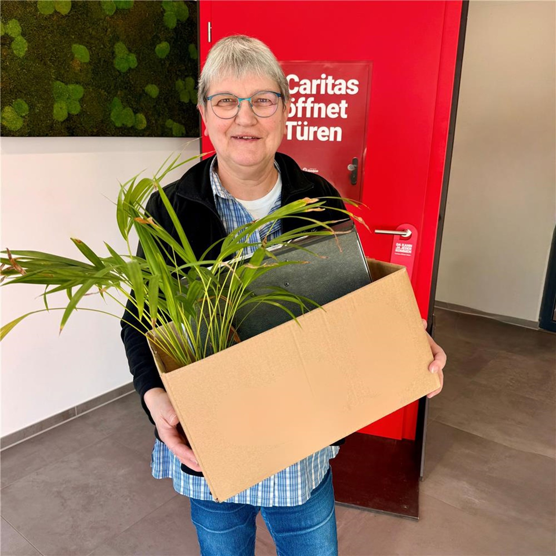 Schwester Barbara Spiegelhoff steht mit Umzugskarton im Caritas-Zentrum.