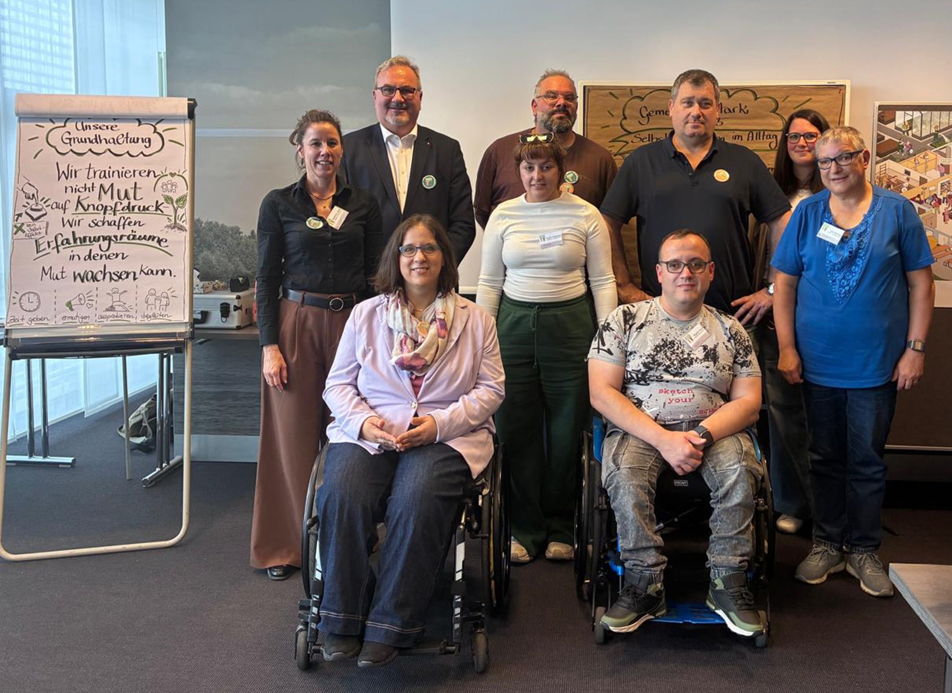 Gruppenfoto eines Workshops mit Teilnehmenden, zwei Personen im Rollstuhl im Vordergrund.