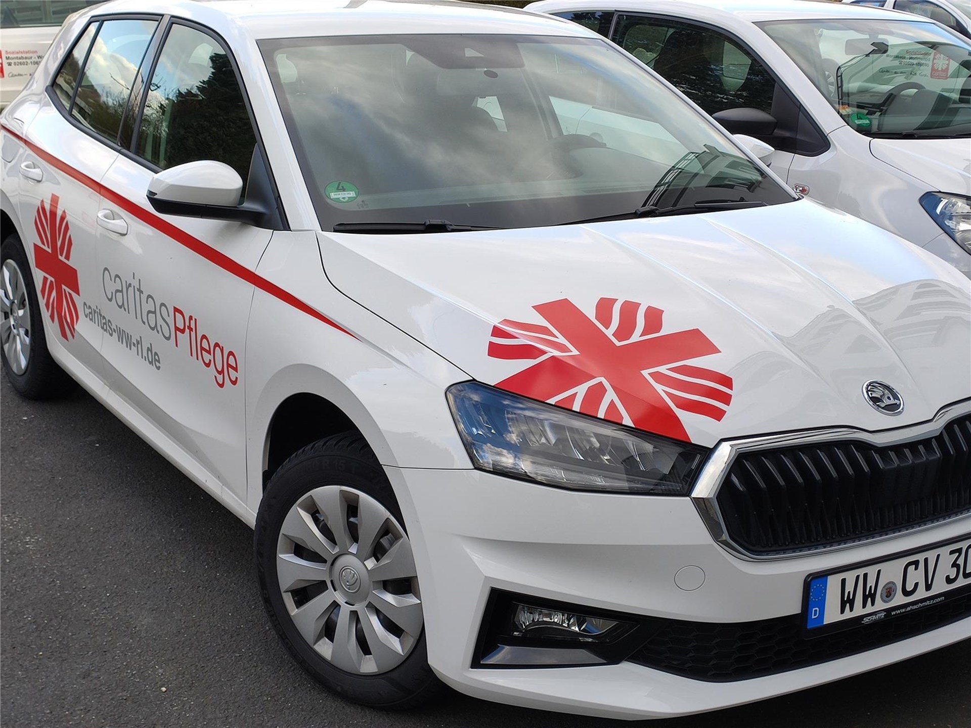 Ein weißes Caritas-Autos mit dem roten Flammenkreuz.